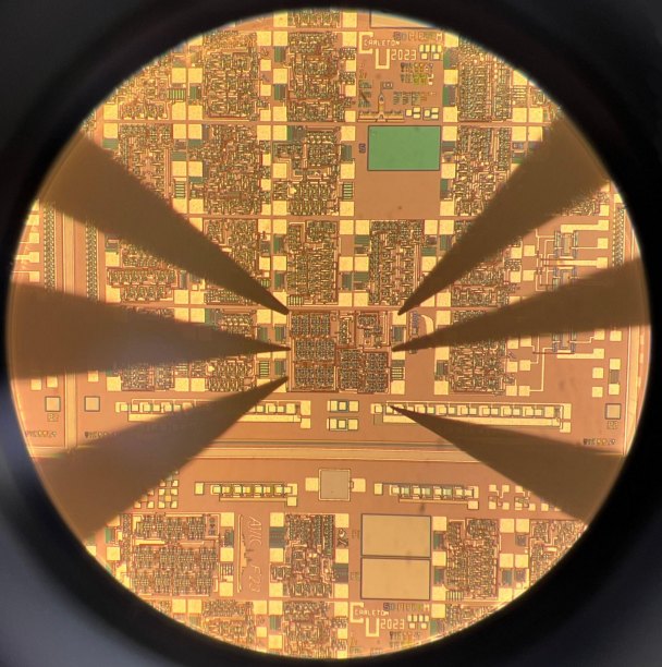 Fabricated PRSG die under a microscope with probe needles, marked Carleton 2023
